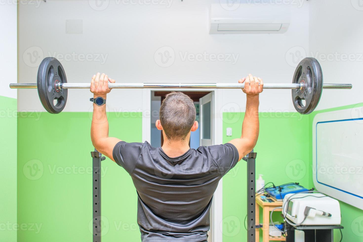 A boy lifts weights in the gym photo
