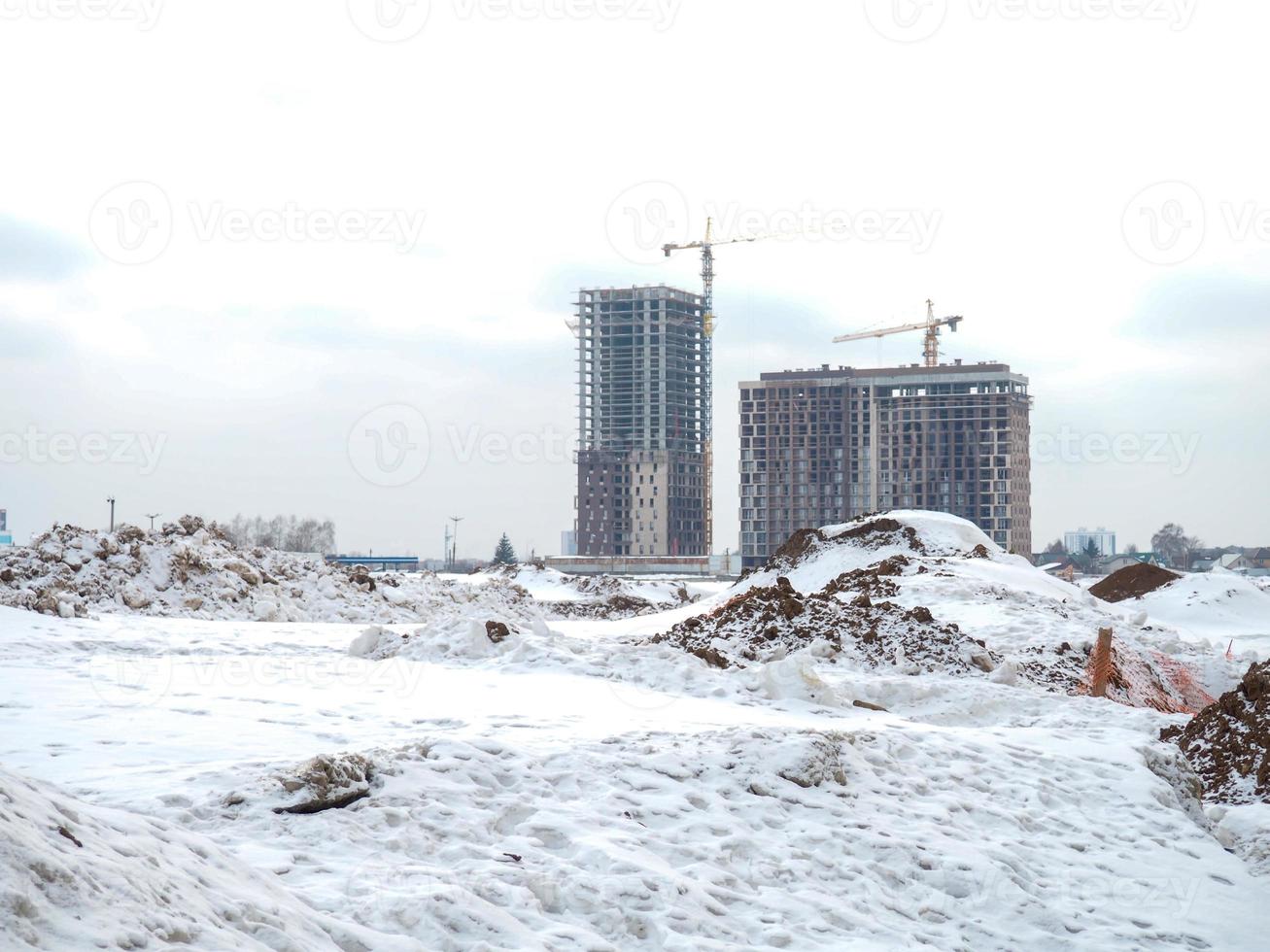 Construction of high-rise buildings in winter. High cranes.  Concrete building frames photo