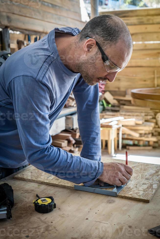 Portrait of a carpenter working in the wood workshop. photo