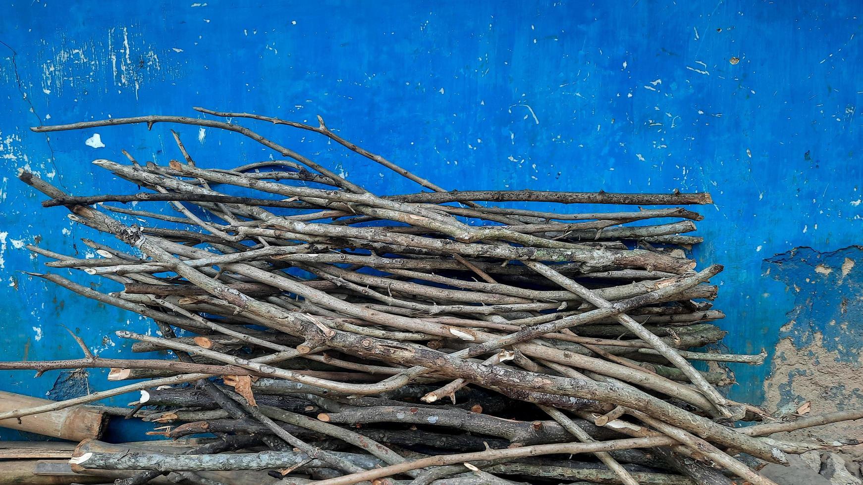 Dry firewood on a vintage blue wall photo