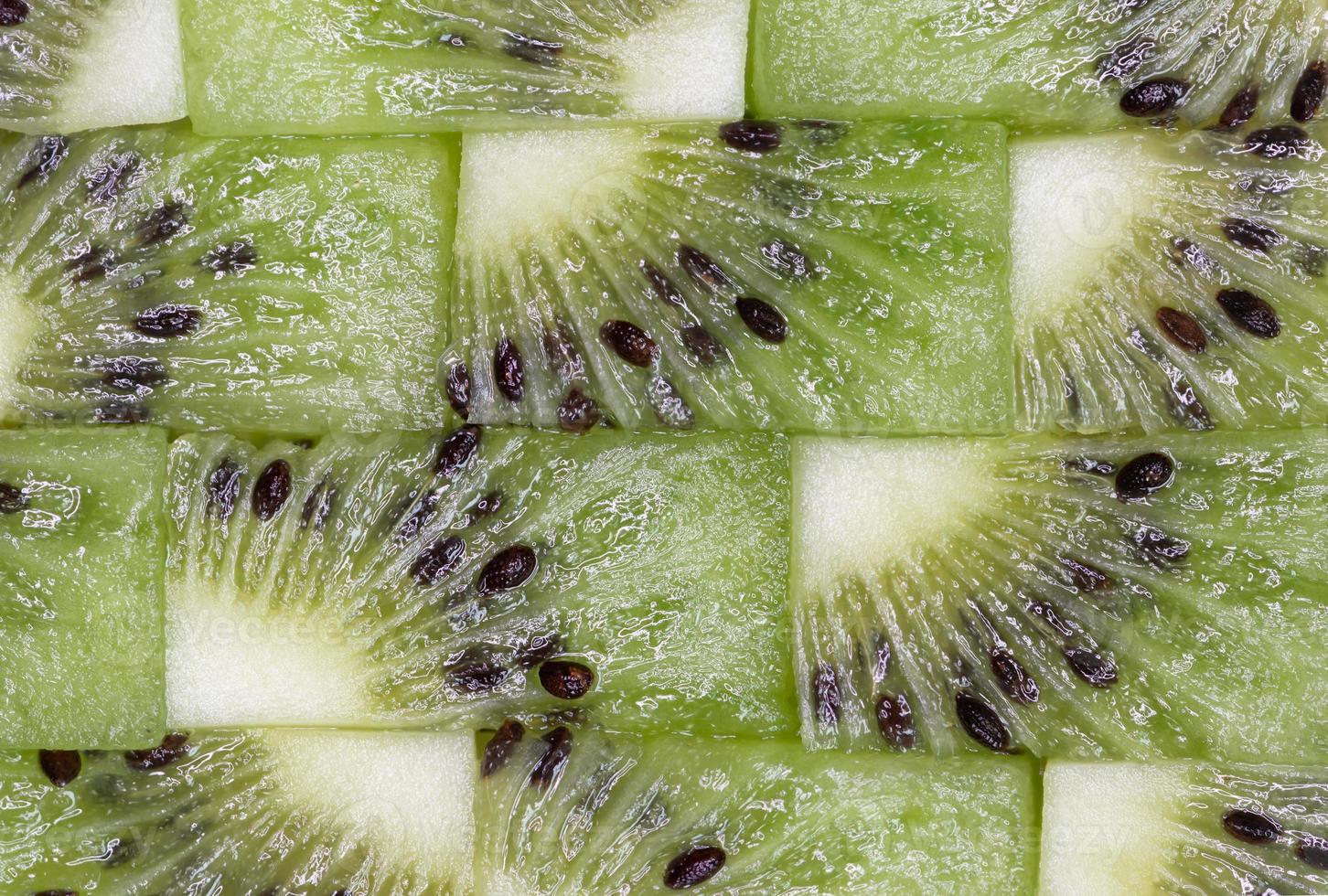 Kiwi cut into small pieces and put them in order like jigsaws, fresh fruit, natural background. photo