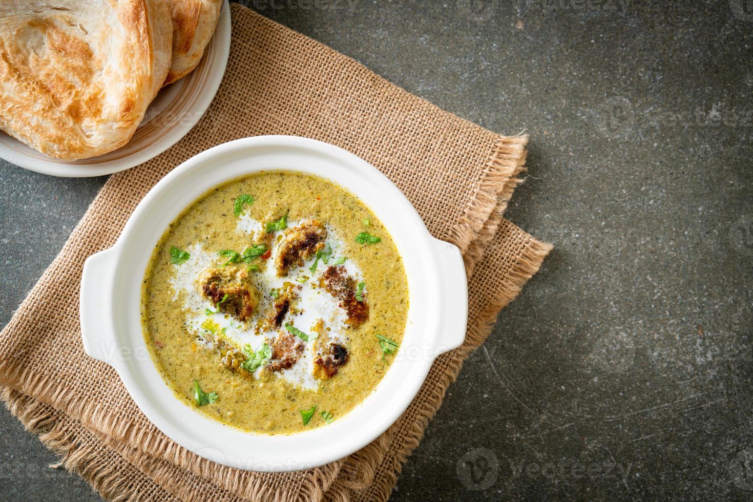 Afghani chicken in green masala curry or Hariyali tikka chicken hara masala with roti or naan bread photo