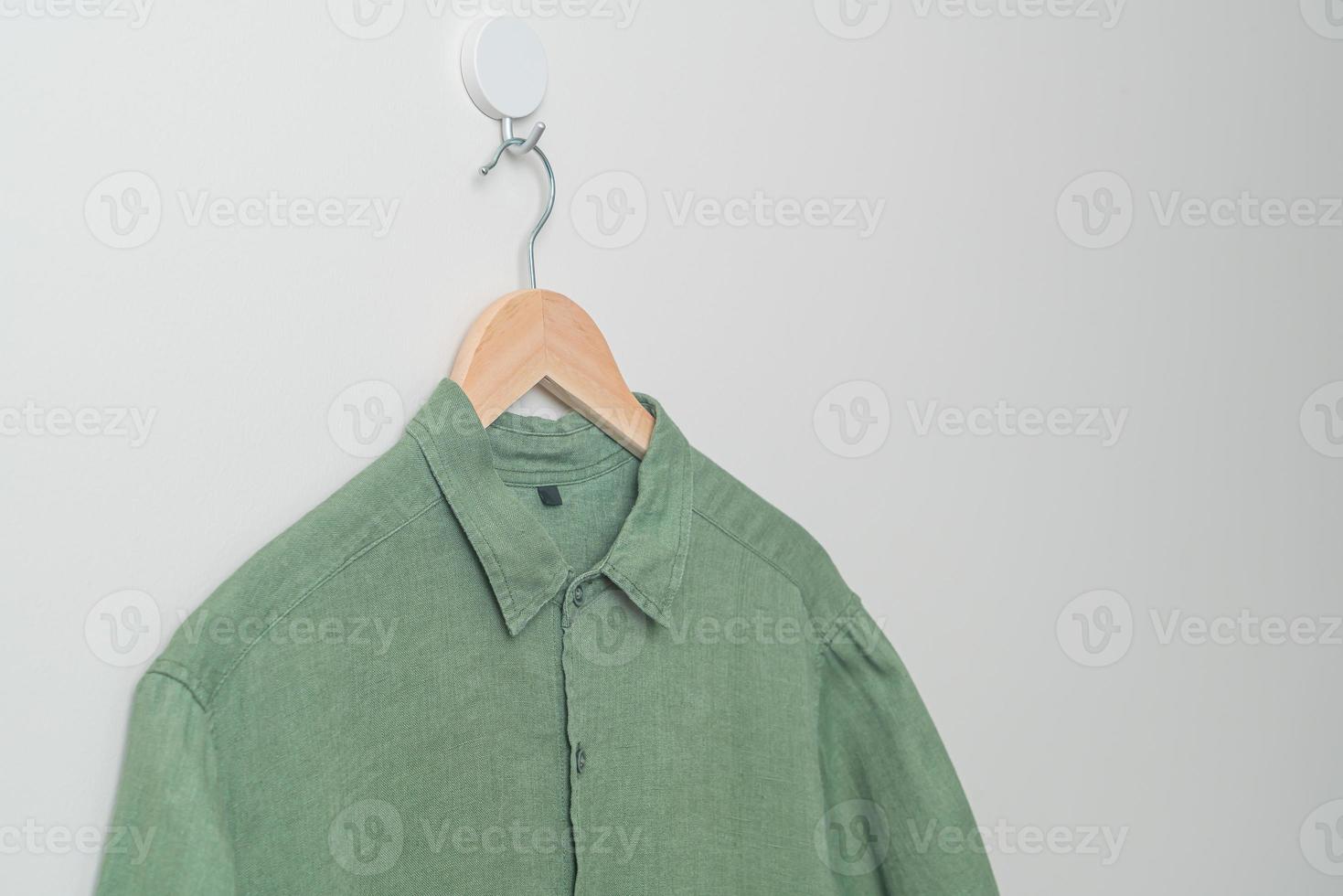 hanging shirt with wood hanger on wall photo