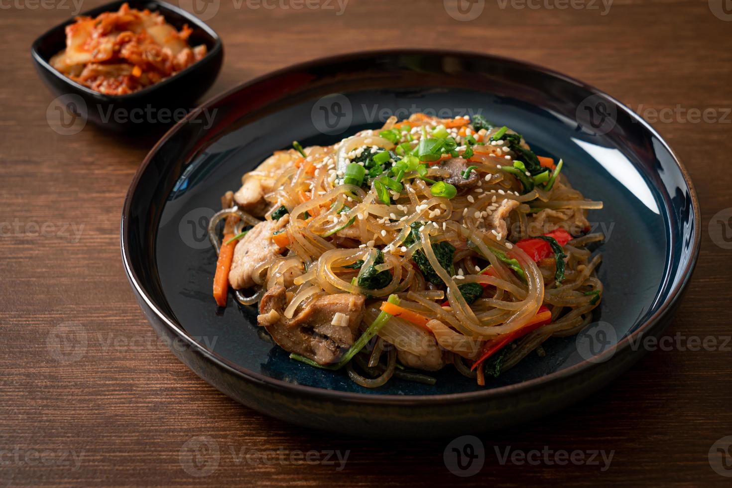 japchae o fideos de fideos coreanos salteados con verduras y carne de cerdo con sésamo blanco foto