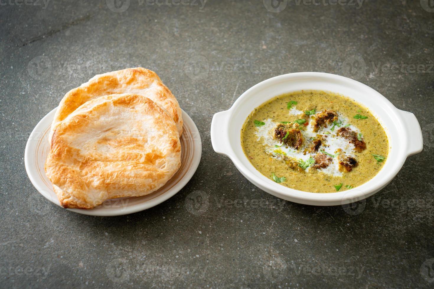 Afghani chicken in green masala curry or Hariyali tikka chicken hara masala with roti or naan bread photo