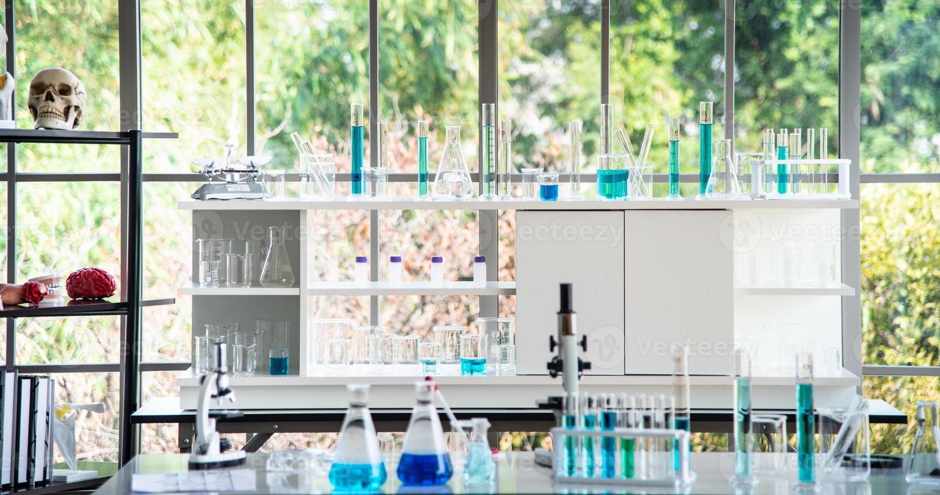 Preparing Laboratory equipments such as glassware, tube with blue liquid on the white table. The chemistry experiment in scientific research photo