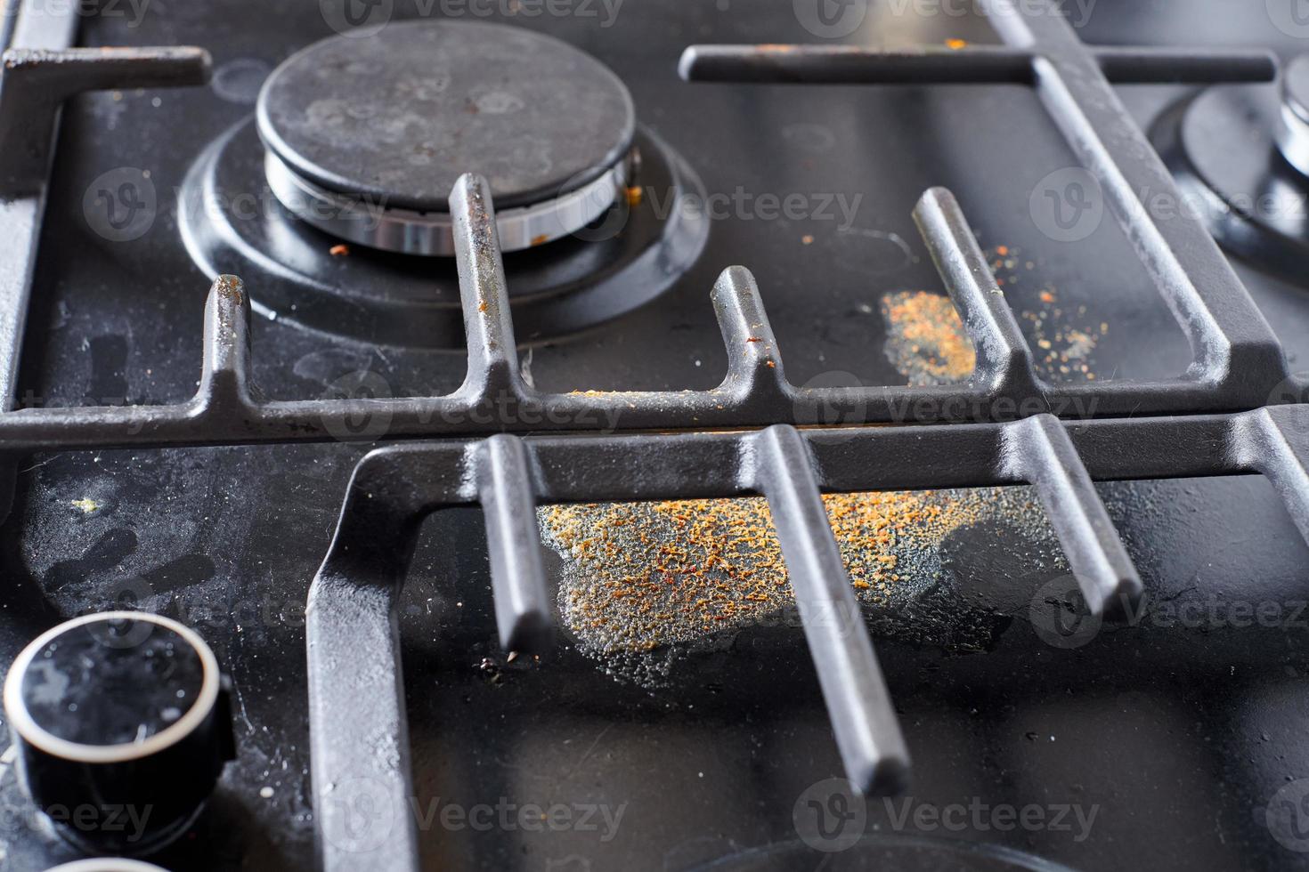 Unclean dirty kitchen black stove after soup boil over, dried food spots, fat stains dry food leftovers photo