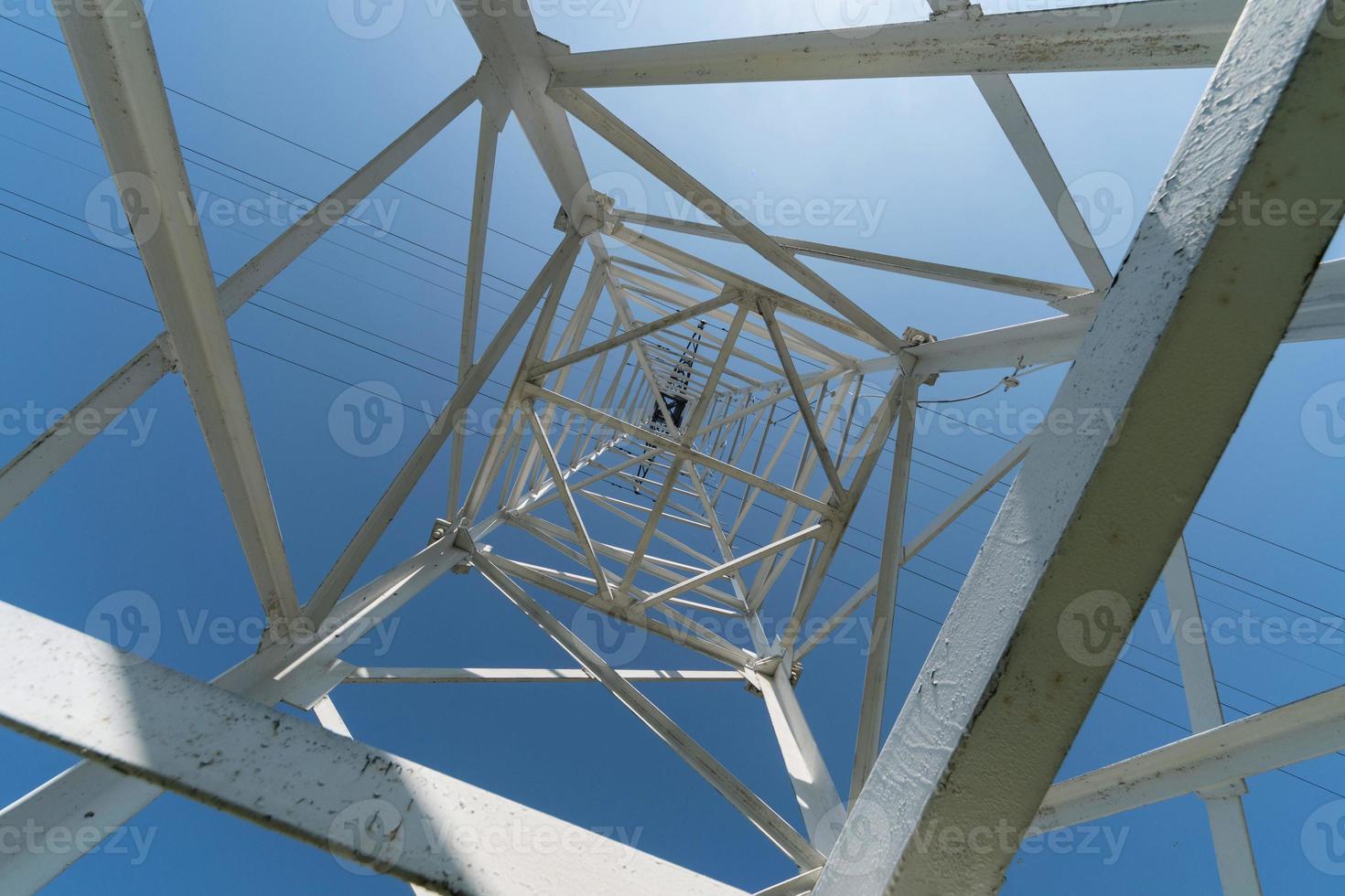 Transmission tower, view from below. Overhead pylon power line tower, distribution and transmit electrical energy across large distances. photo