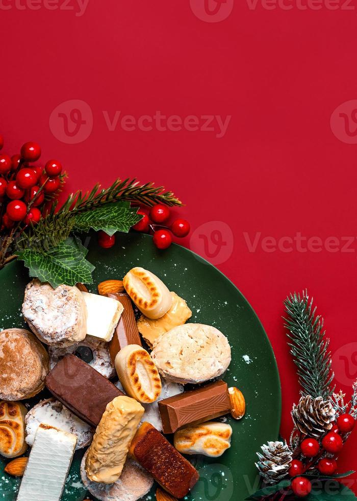 Top view of Nougat christmas sweet,mantecados and polvorones with christmas ornaments on a plate. Assortment of christmas sweets typical in Spain photo