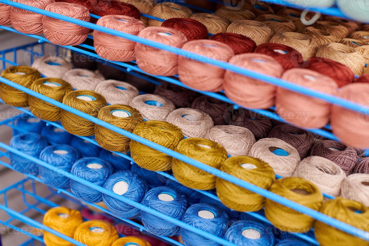 Yarns or balls of wool on shelves in store for knitting photo