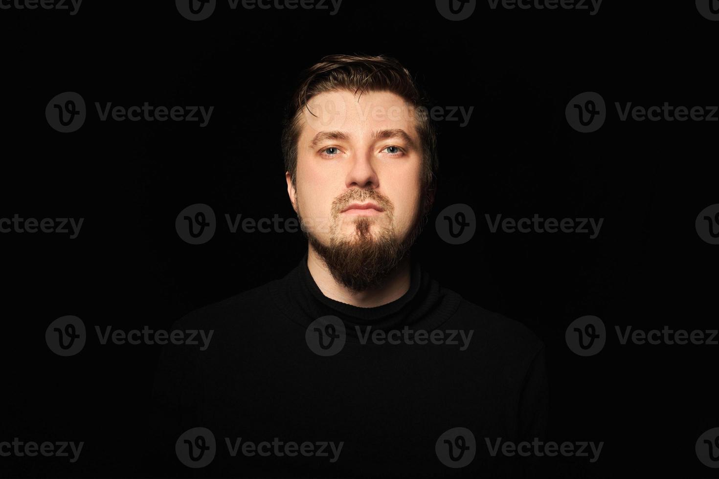 Cute bearded young guy in black polo neck sweater. photo