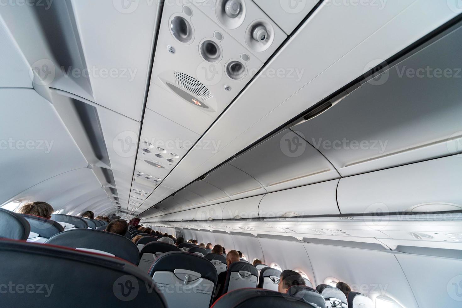 panel de control del aire acondicionado del avión sobre los asientos. aire viciado en la cabina del avión con gente. nueva aerolínea de bajo costo foto