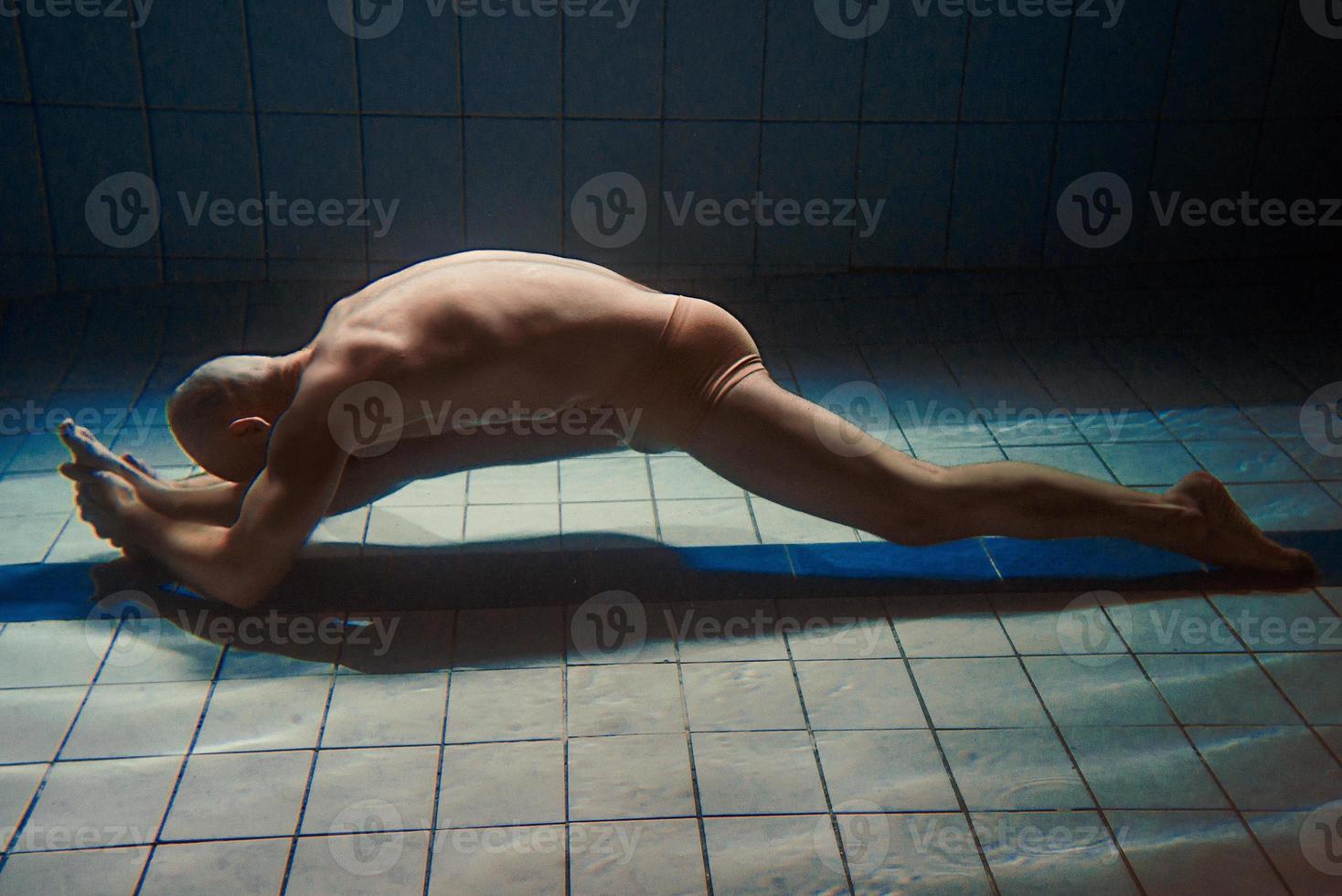 hombre de deporte atlético bajo el agua en la piscina. deportes, yoga, concepto de buceo libre foto