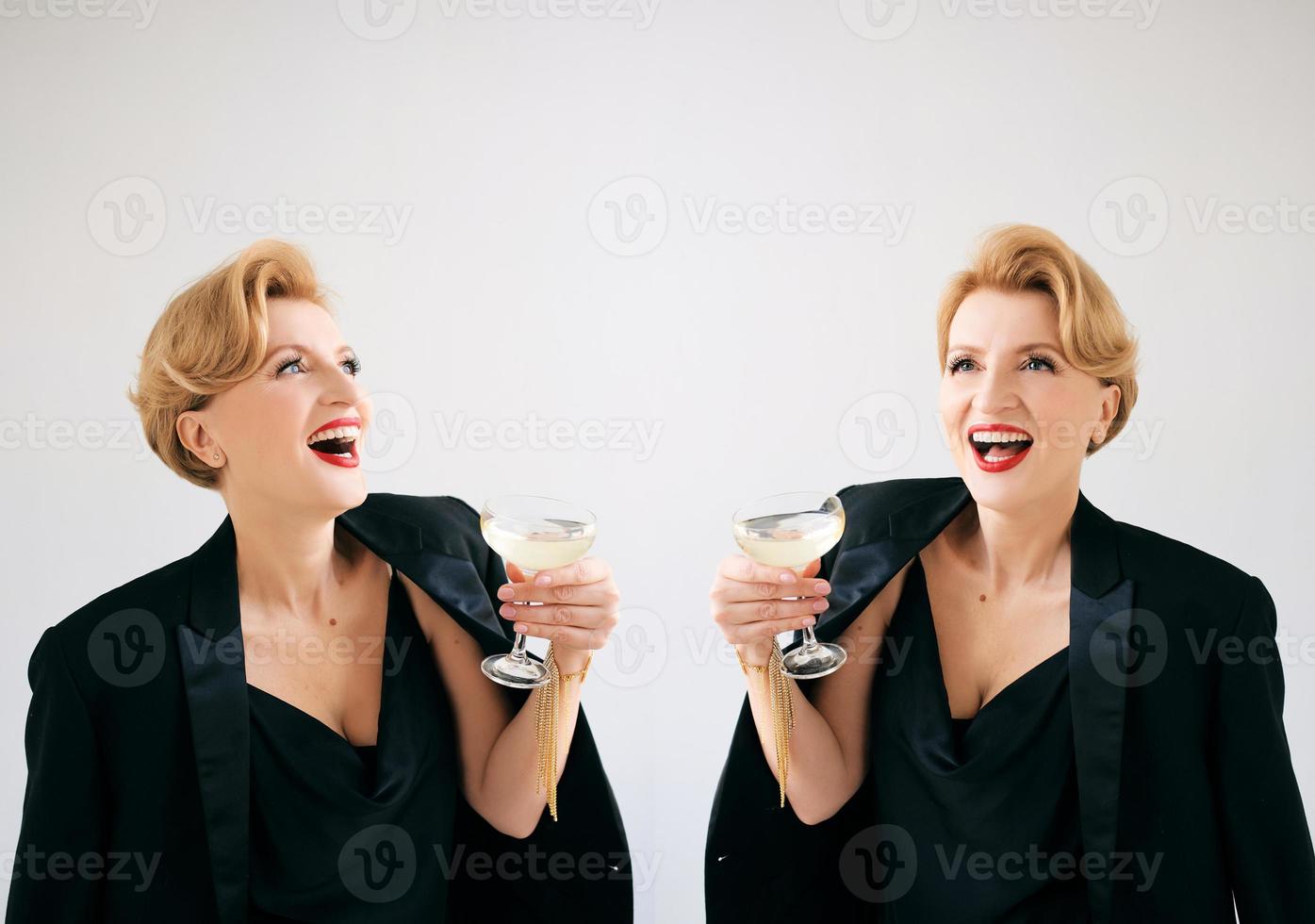 two mature stylish elegant women twins in tuxedo with glass of sparkling wine. Party, celebration, anti age concept photo