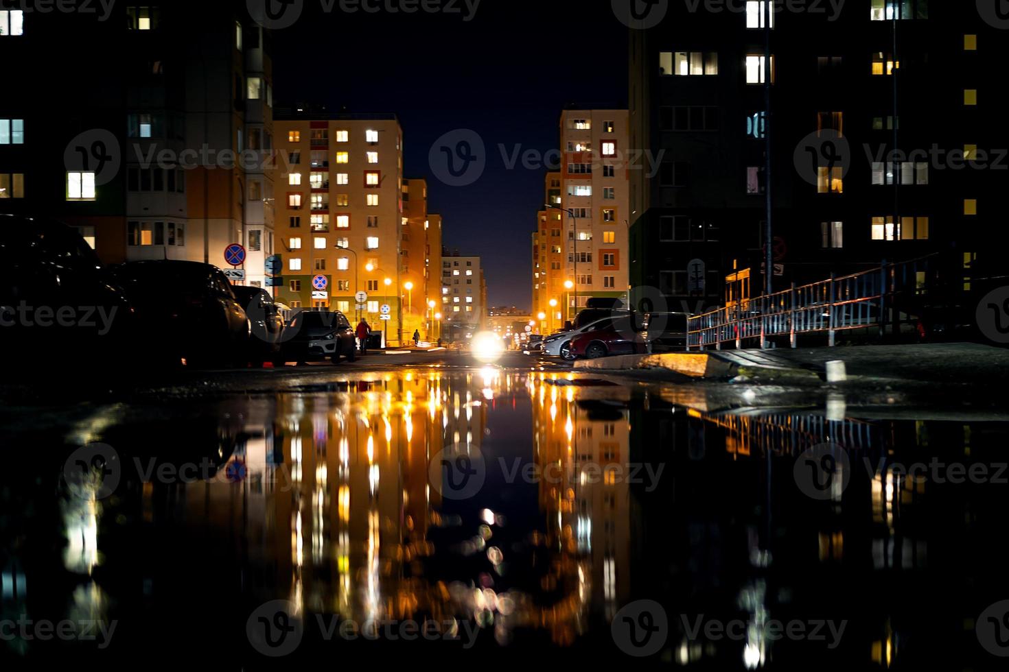 vida nocturna, edificios modernos de la capital con el reflejo de la luz en los charcos. foto