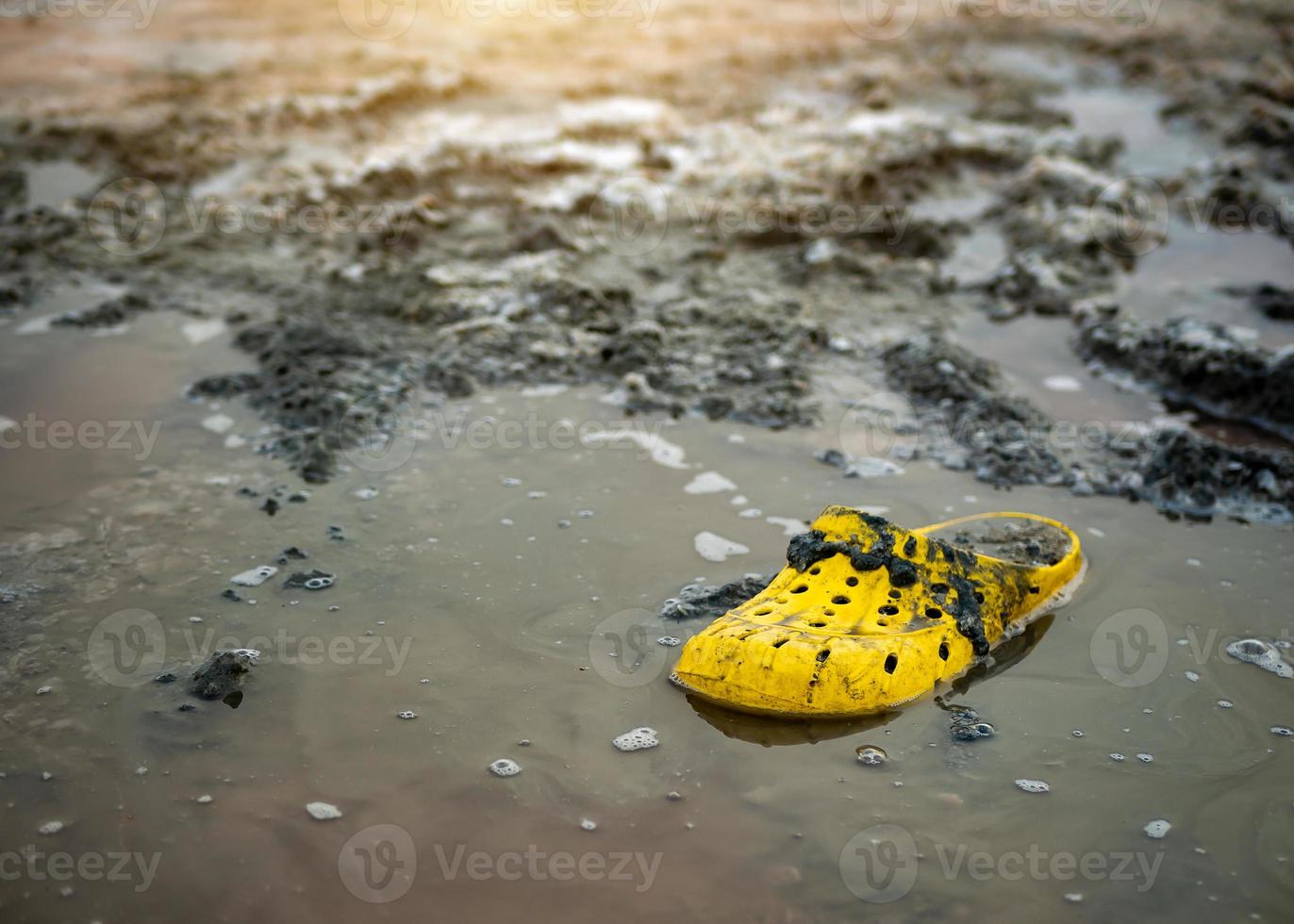 very dirty yellow Shoe on the shore of a salt lake on a Sunny day. photo