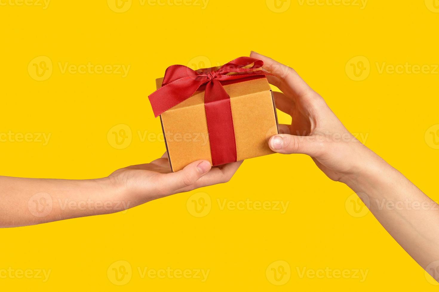 Transfer of the order. Giving a gift to a loved one. Hand to hand on a yellow background. Delivery of purchases. photo