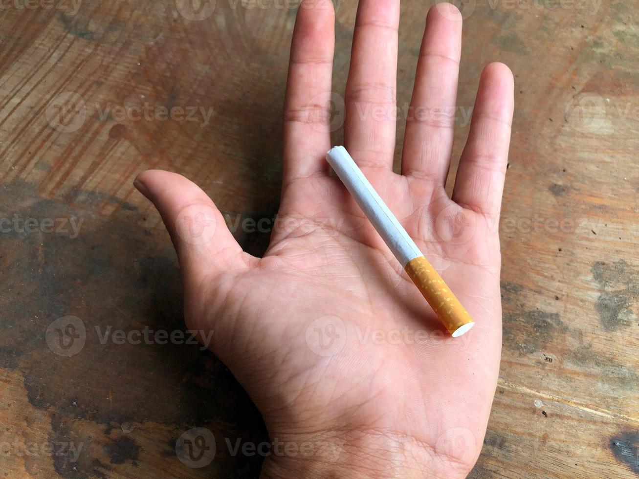 A cigarette in the palm of the hand photo