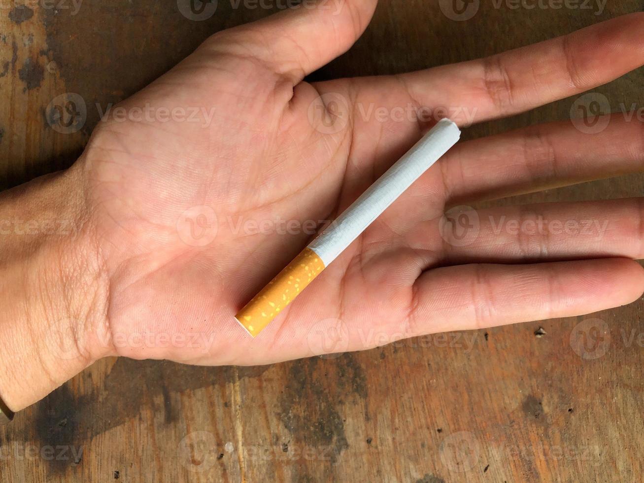 A cigarette in the palm of the hand photo