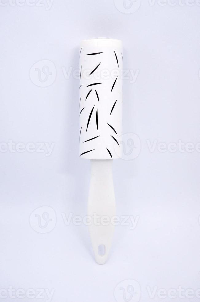 LINT ROLLER CLEANING TOOL FOR DOG CAT FUR IN CLOTHING ISOLATED ON WHITE BACKGROUND photo