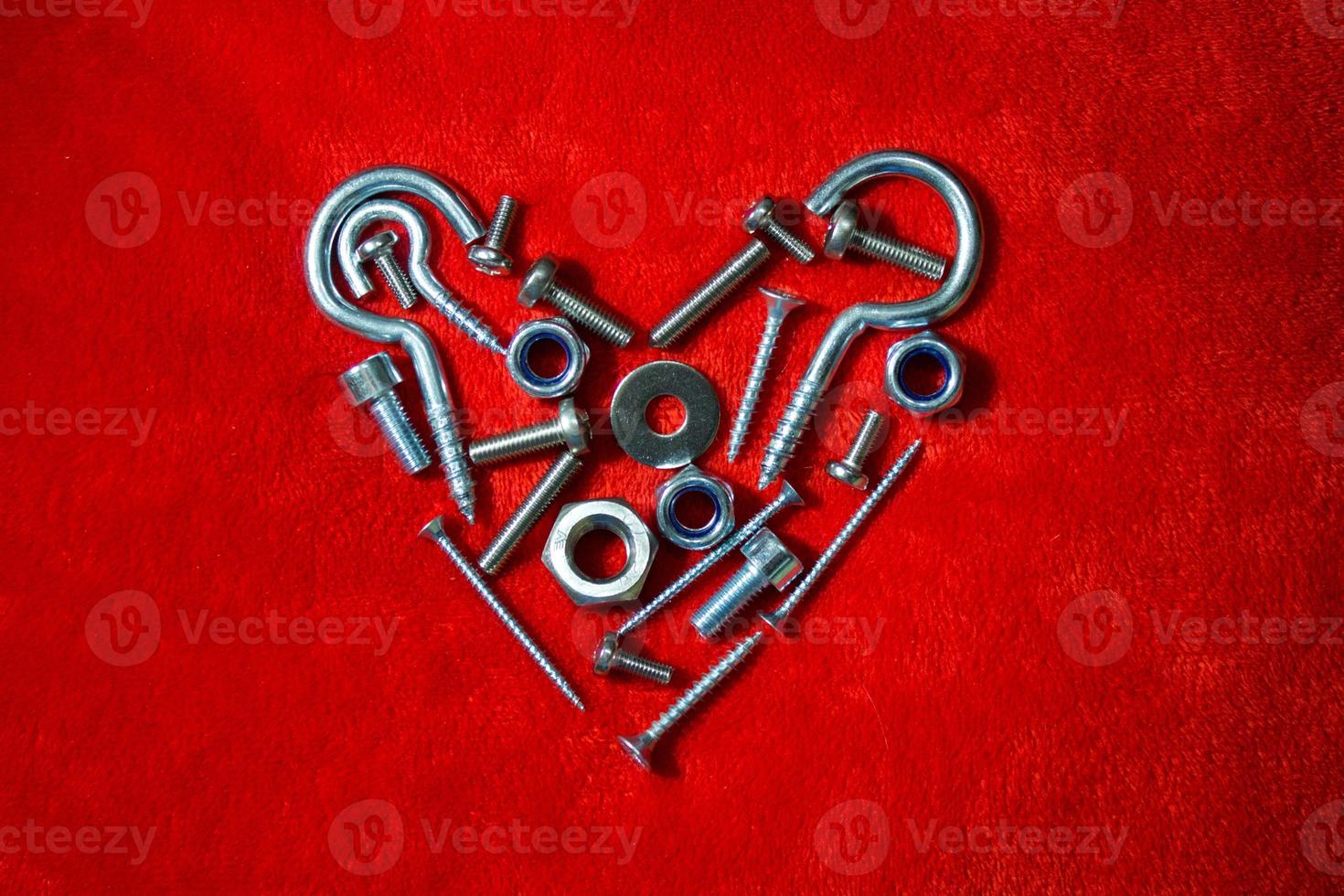 Bolts, nuts, hex and other construction tools laid out in a heart shape, Valentines day postcard, banner, wallpaper, cover design, holiday concept. Flat lay, top view photo