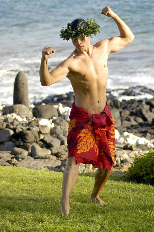 A masculine male hula dancer exhibits his traditional hula style. photo