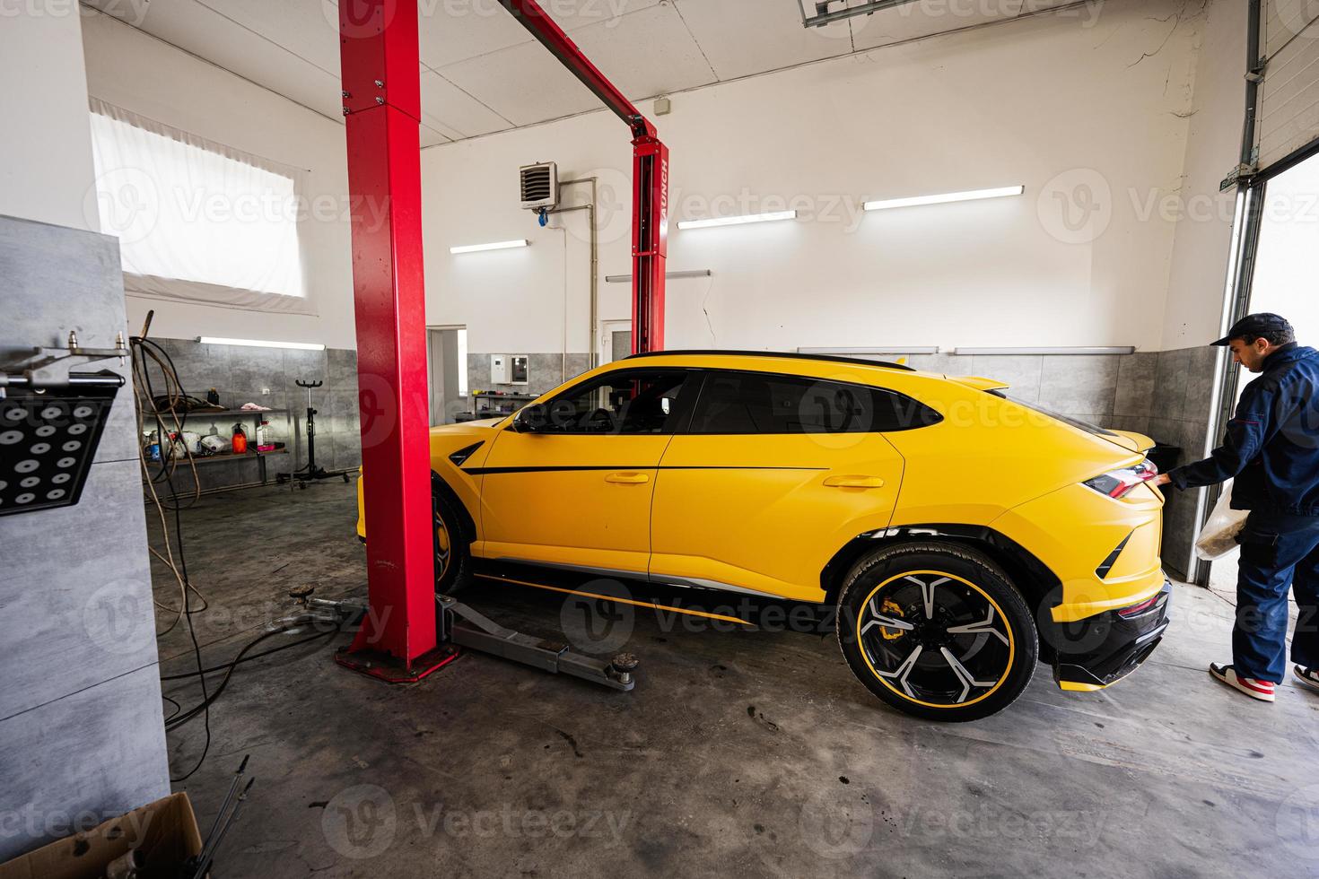 Mechanic open trunk of yellow sport car suv. photo