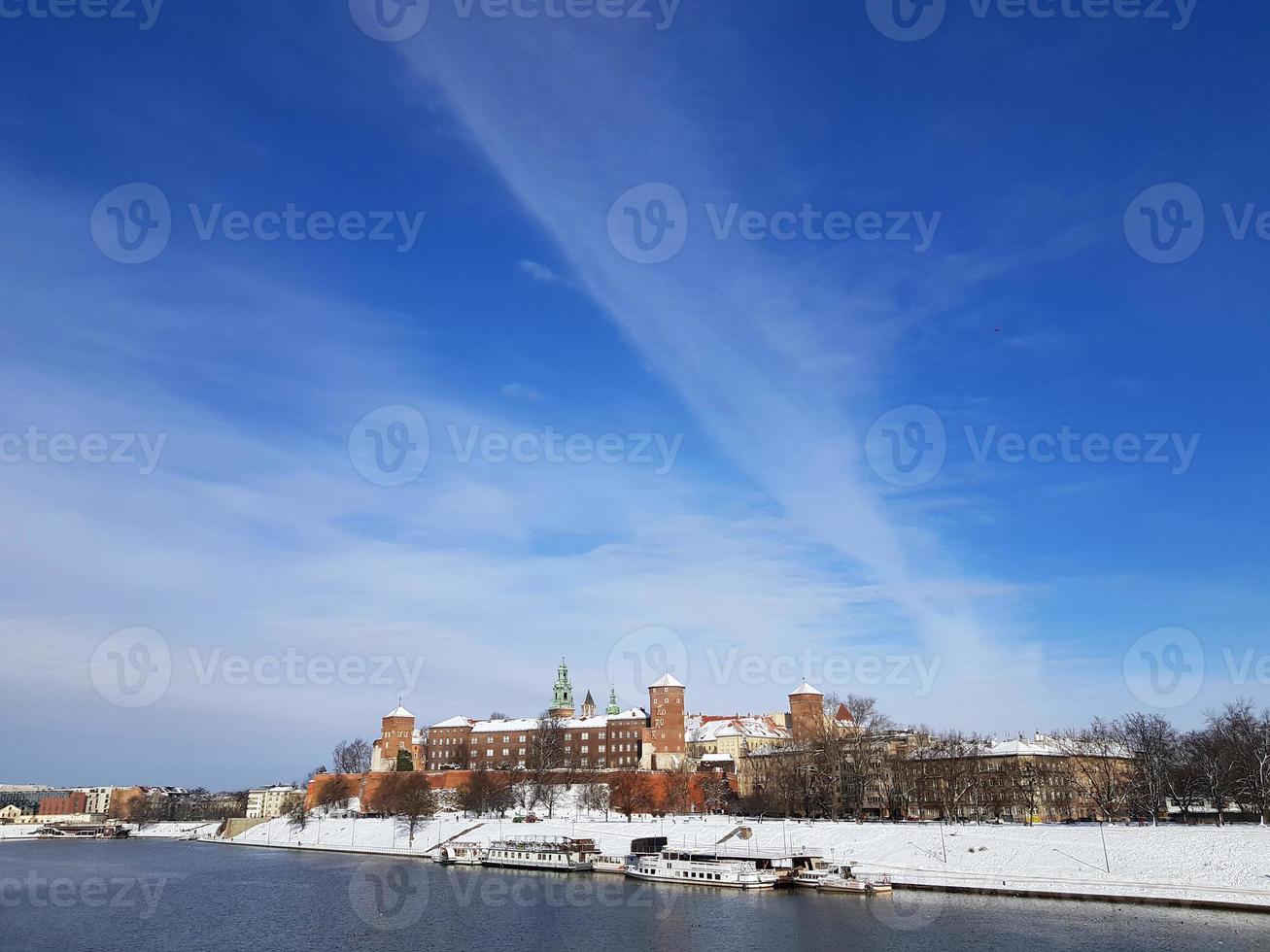 Panorama of The Wawel Royal Castle located on the left bank of the Vistula River in city Krakow, Poland. Sunny winter day, big blue sky, white clouds lines. Place for text. photo