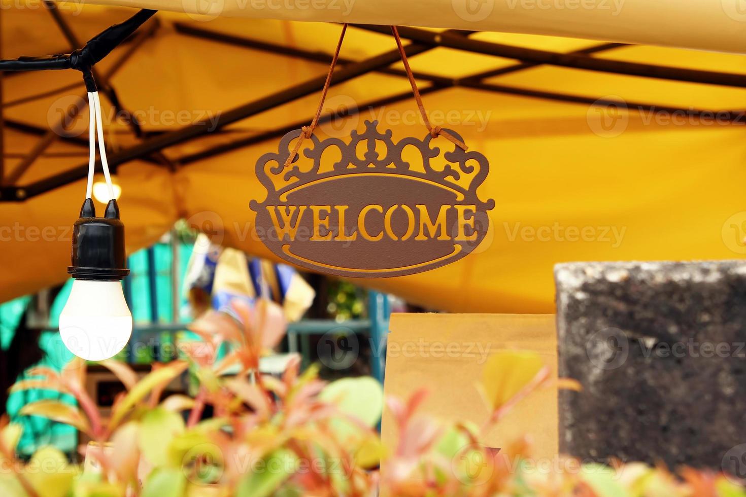 cartel con inscripción bienvenido en un café sobre un fondo amarillo. foto