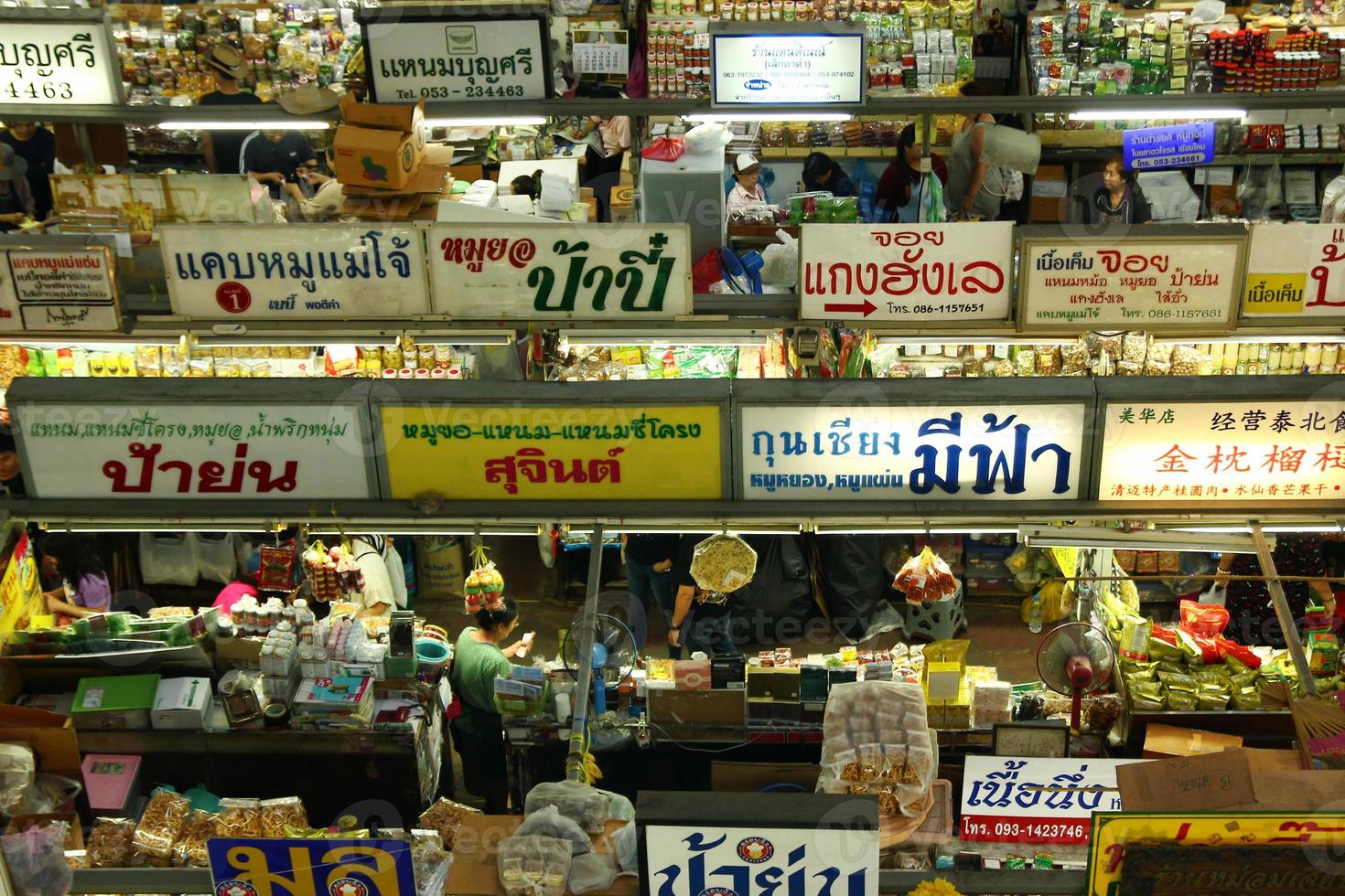 chiang mai, tailandia, 2 de enero de 2018. vista superior en el mercado de alimentos con diferentes alimentos locales, letreros, gente local y turistas. foto