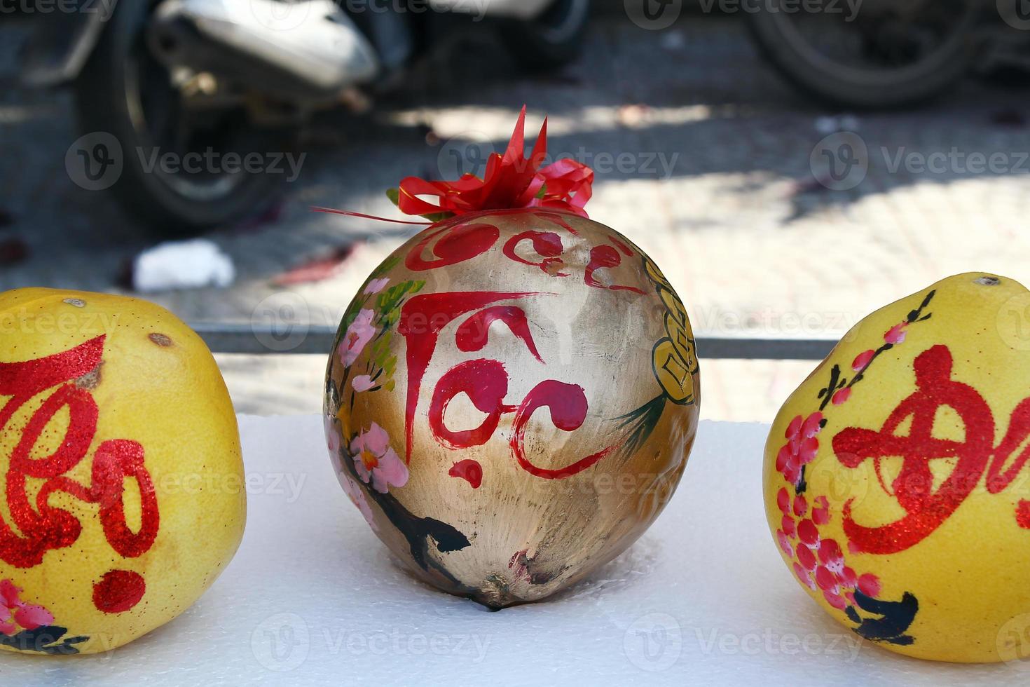 tres pomelos decorados para la celebración del año nuevo vietnamita en un mercado en hoi an, vietnam. la inscripción se traduce - fortuna. foto