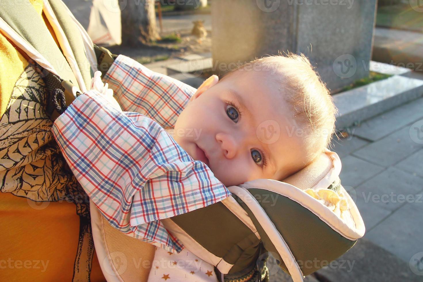 Cute little girl in ergo carrier on a walk with her father. photo