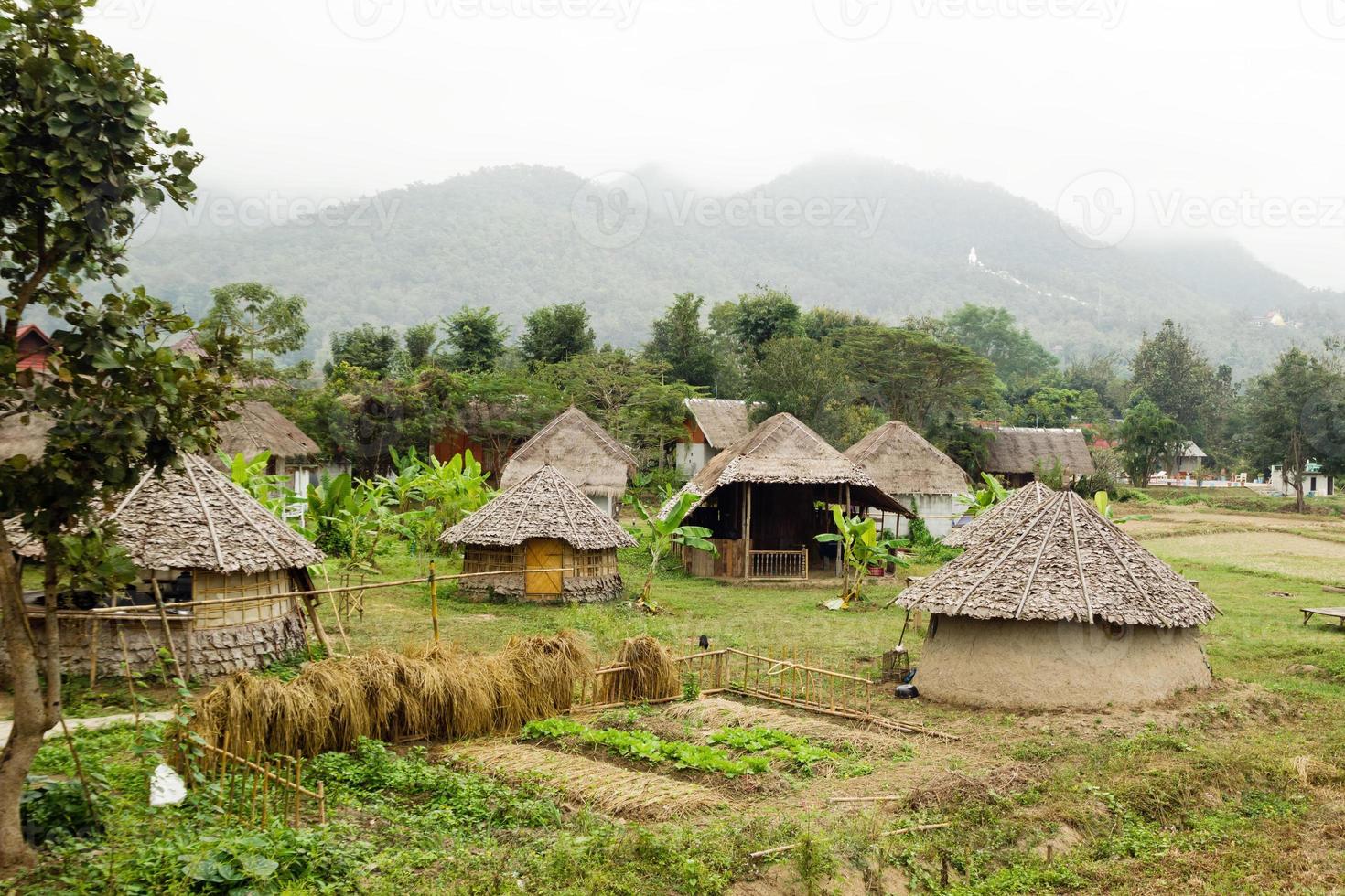 vista sobre casas de madera y jardín sobre un fondo de montañas en tiempo nublado. Pai, provincia de Mae Hong Soon, Tailandia. foto