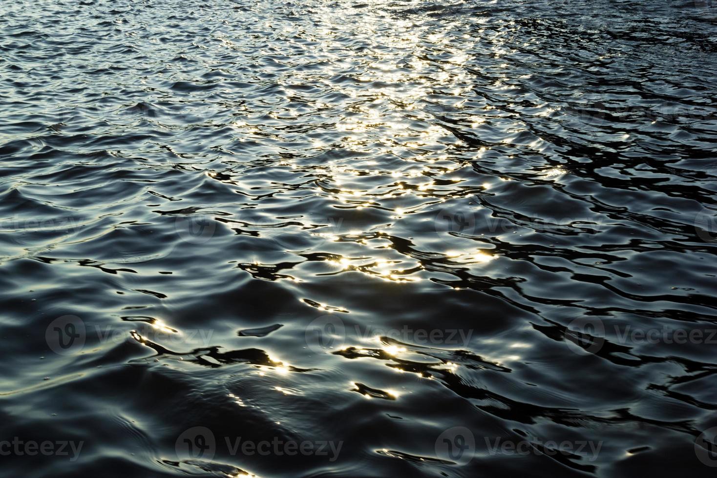 reflejo del sol en el agua durante una puesta de sol. foto