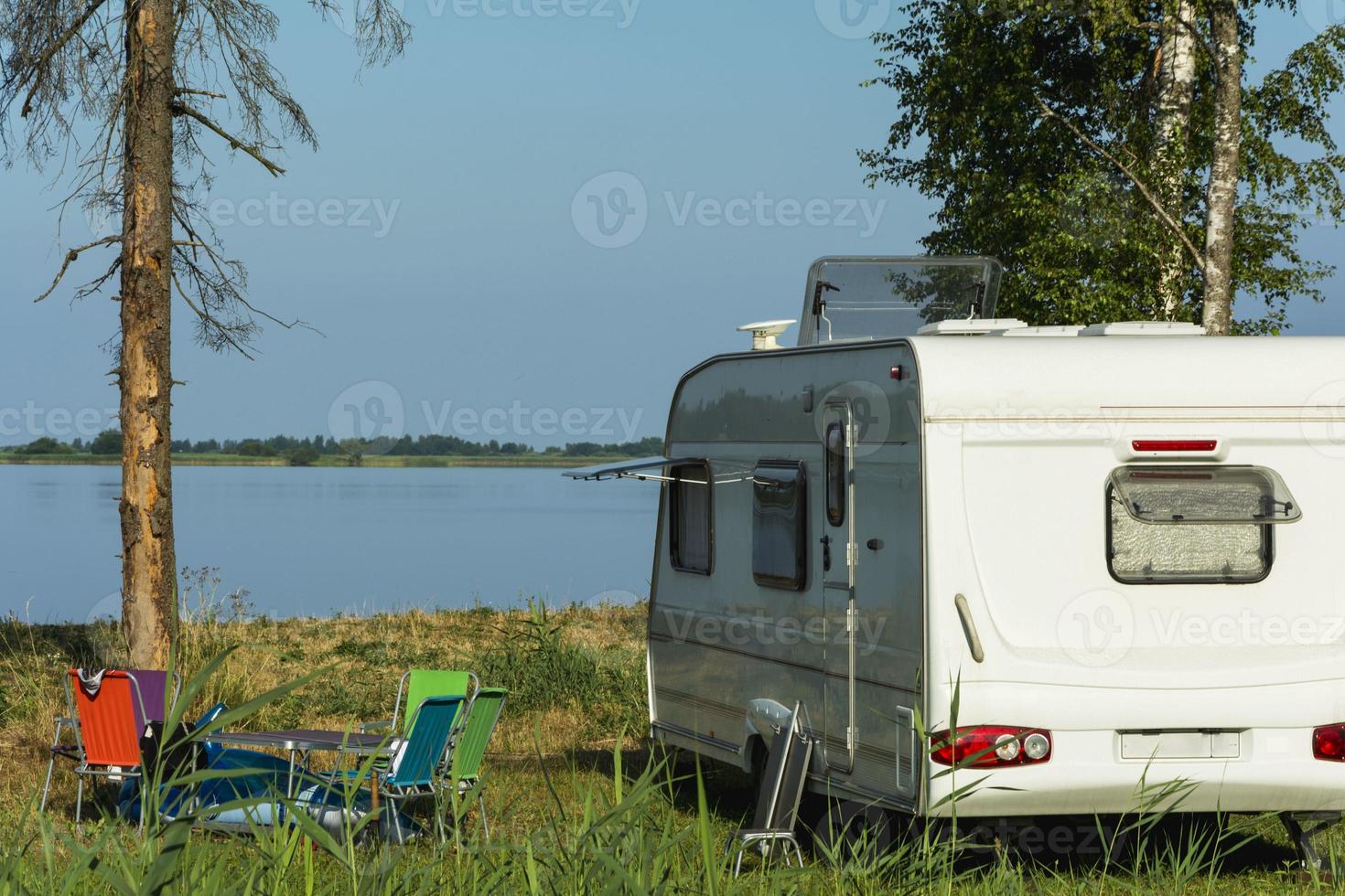 Camper trailer in nature on the background of the lake, tourism, travel, outdoor recreation, active lifestyle photo