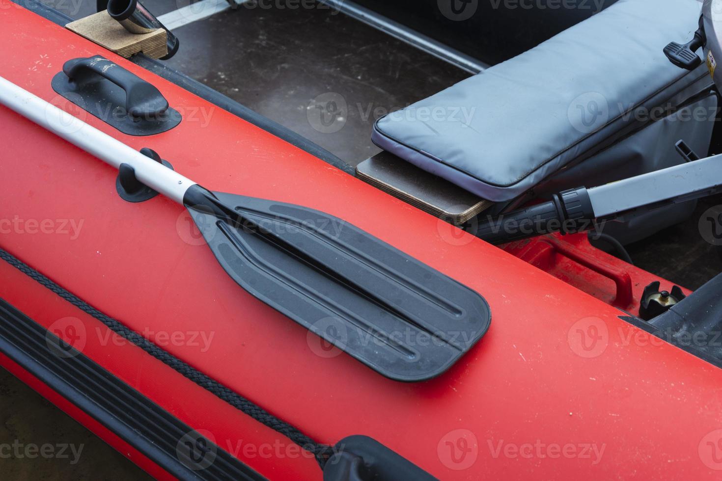 Paddle on board a rubber inflatable boat, red inflatable boat with a paddle, tourism, active lifestyle, fishing photo