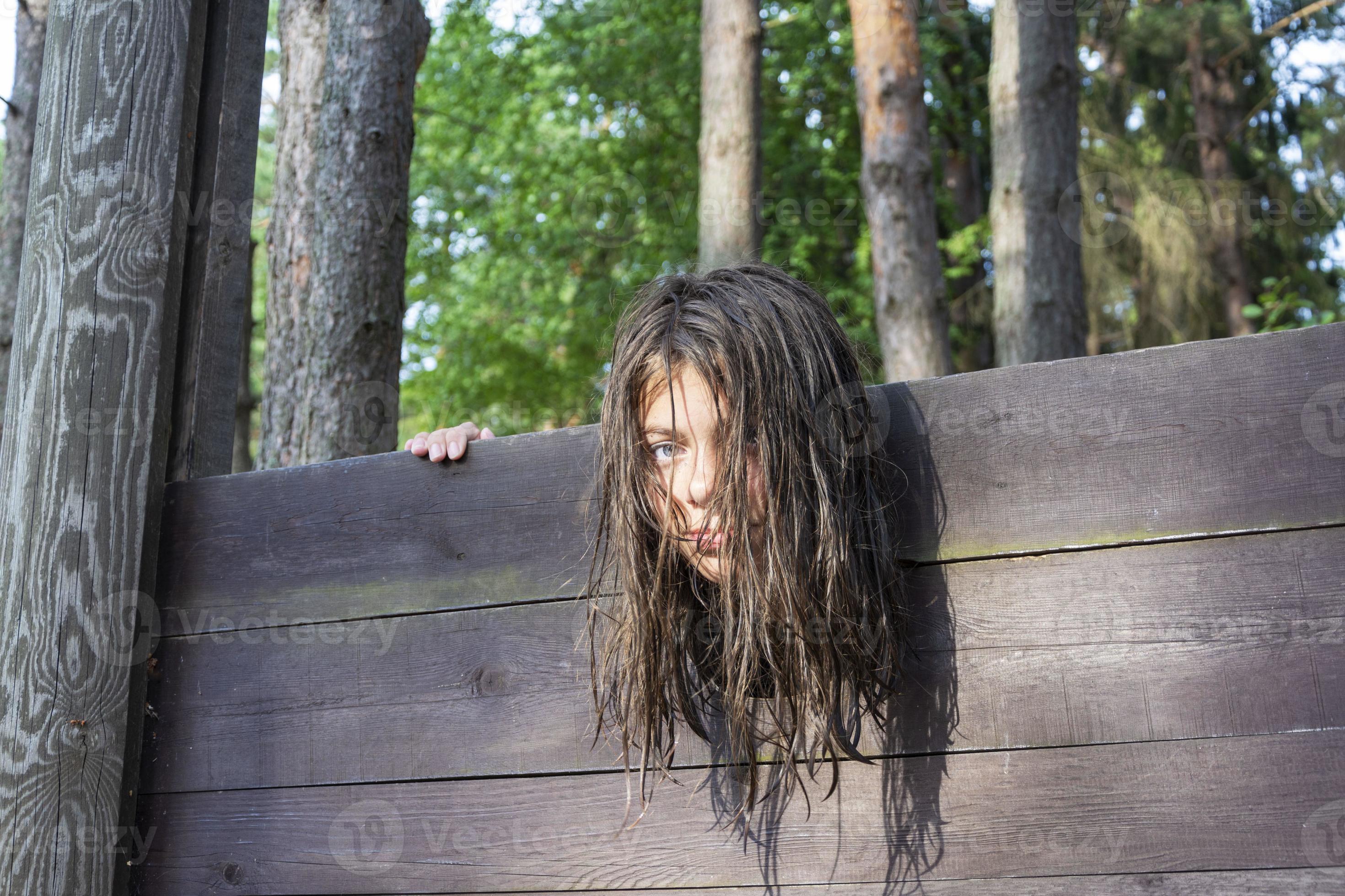 the head of a girl with long disheveled hair clamped in a guillotine, a