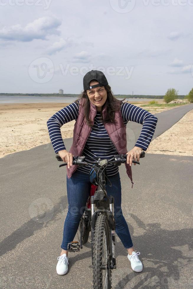 una mujer en bicicleta, andando en bicicleta, un carril bici y una mujer joven y bonita con una bicicleta foto