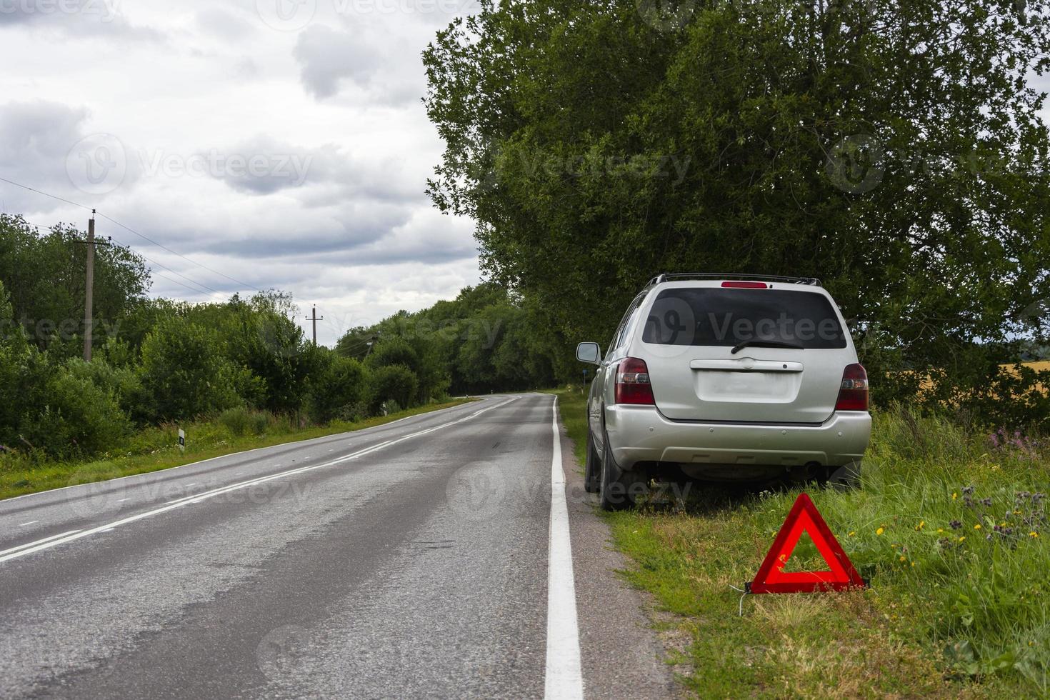 a car waiting for repair after a breakdown, a broken car on the side of the road, an emergency stop sign photo