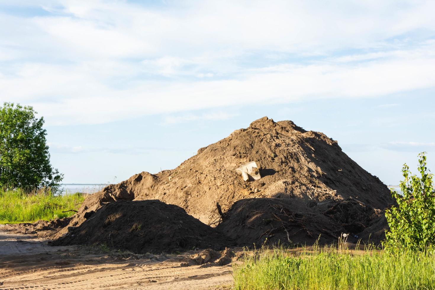 a large pile of land on the shore of the bay, ecology, soil, gentrification of the territory photo