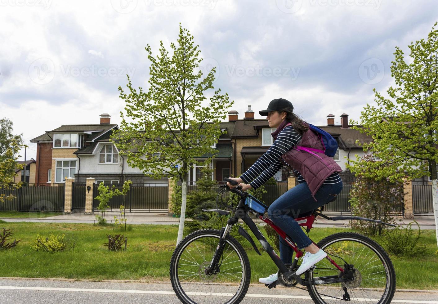 attractive young woman with big thighs rides a bicycle through the city streets photo