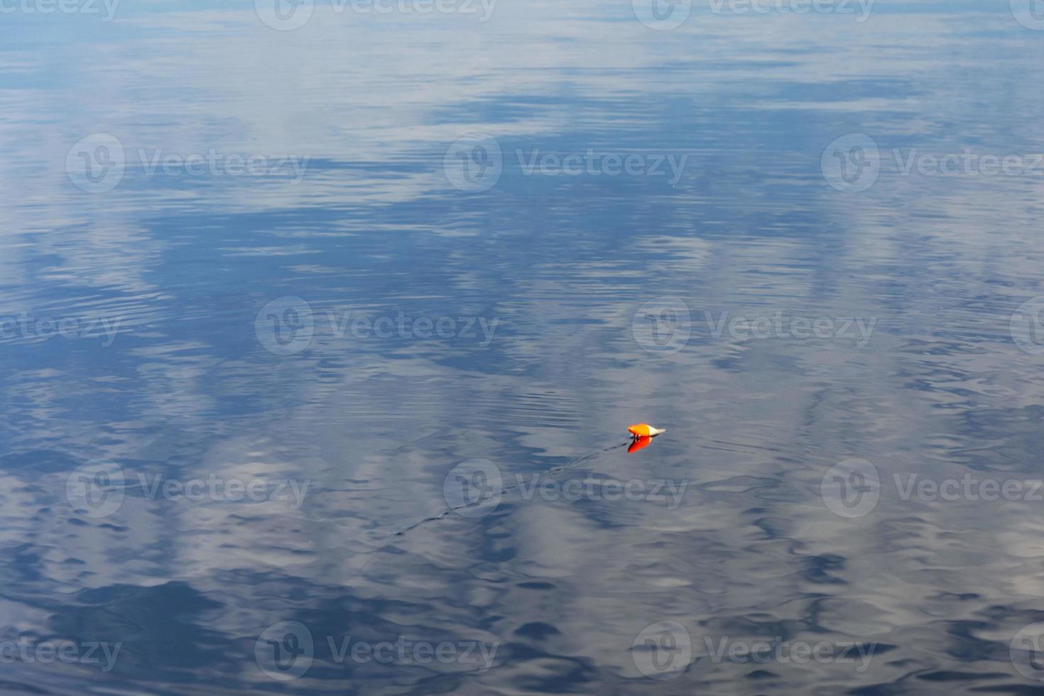 fishing red float on the water surface of the lake, fishing, recreation, relaxation photo