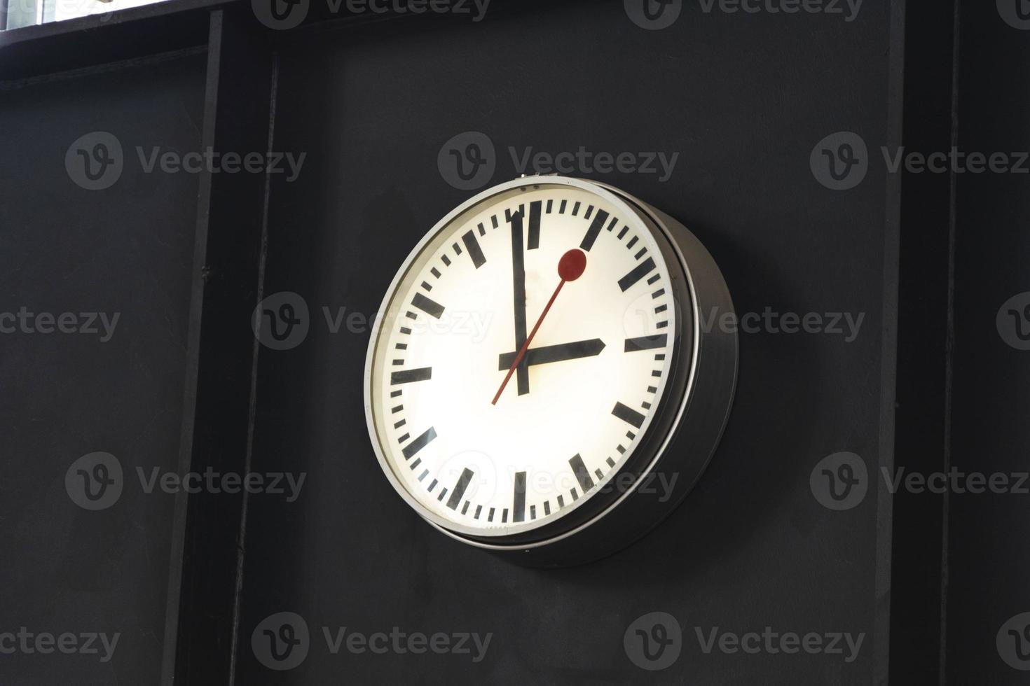 A large clock with hands at the train station in the waiting room photo