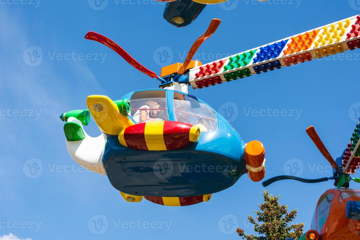children's carousels helicopters in an amusement park, carousels and people during the summer in the city photo