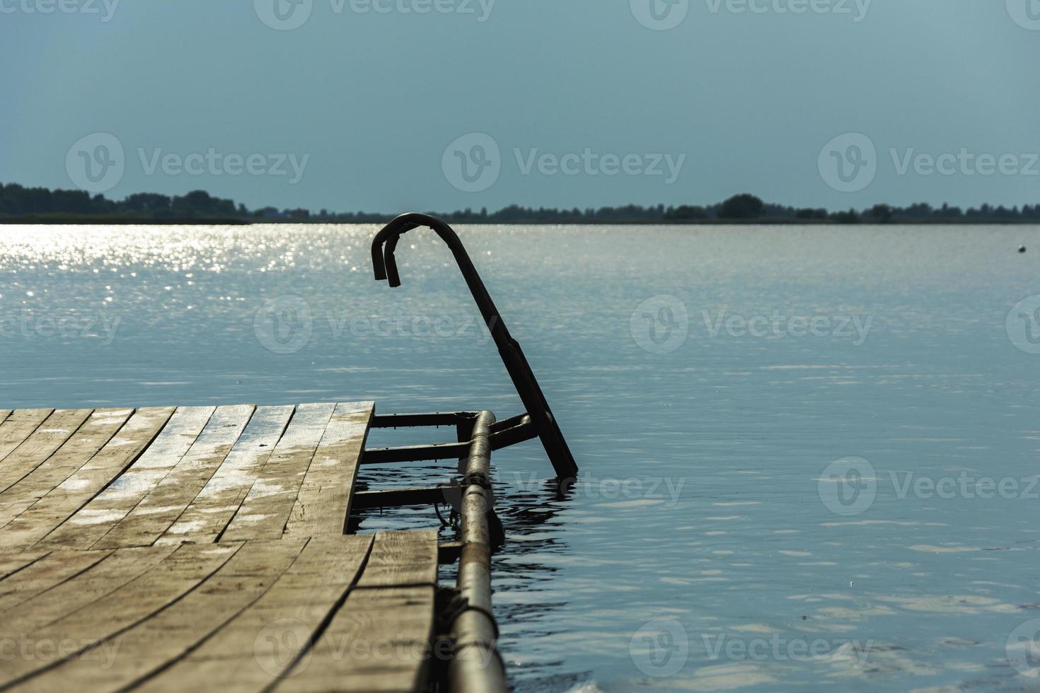 Bridges for swimming in the lake. Wooden boardwalk on the lake for swimming, the background of the lake and the blue sky. For the design of an active lifestyle. Natural landscape photo