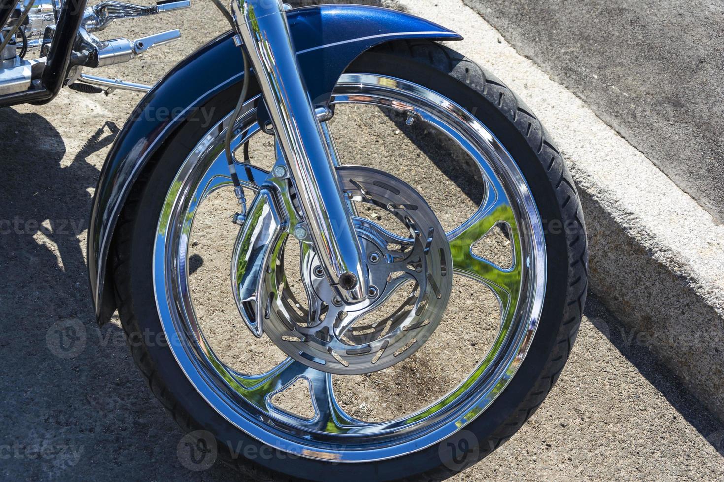 disco de freno de motocicleta en la rueda delantera, pinza de freno y neumático, cromo brillante foto