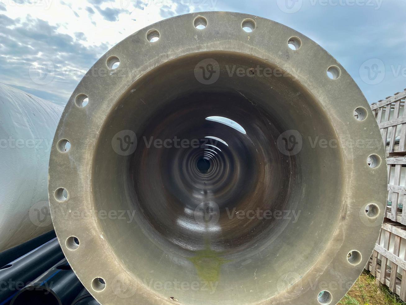 Large diameter plastic polypropylene pipe with flange in open air storage warehouse for storage of materials and industrial equipment photo