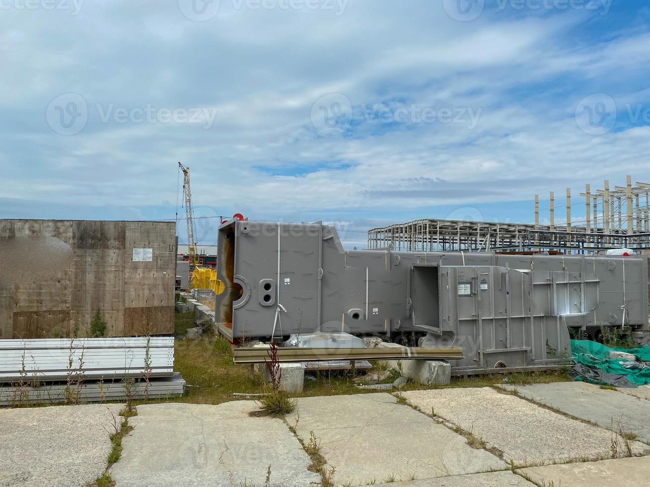 A large outdoor warehouse at a construction site, a warehouse for industrial equipment and materials in boxes at an open-air storage site photo