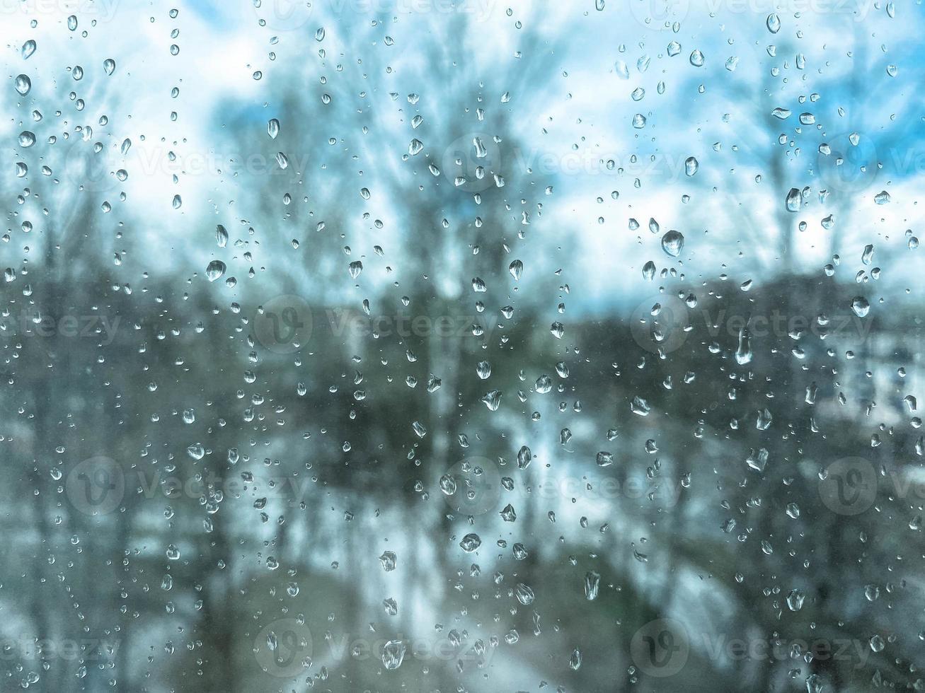 Beautiful surface texture of wet transparent glass in a window with clean cold drops after rain. The background photo