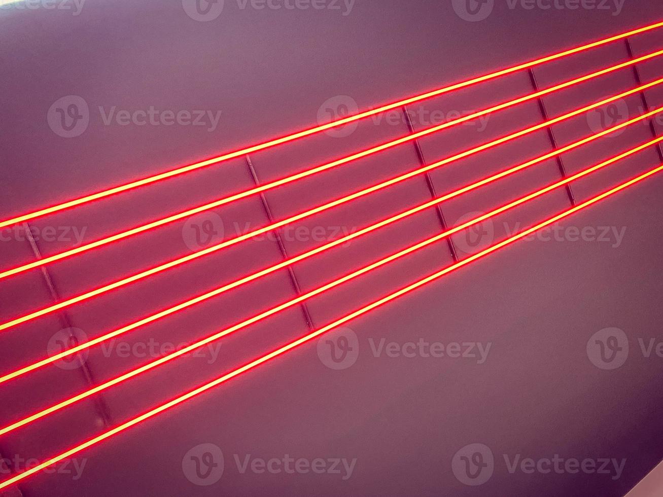 Texture of red glowing bright neon LED multicolored laser abstract stripes and lines from parallel lamps. The background photo